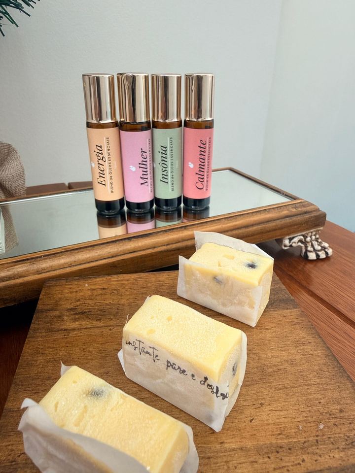 Frascos roll-on aromáticos e quitutes sobre uma tábua de madeira