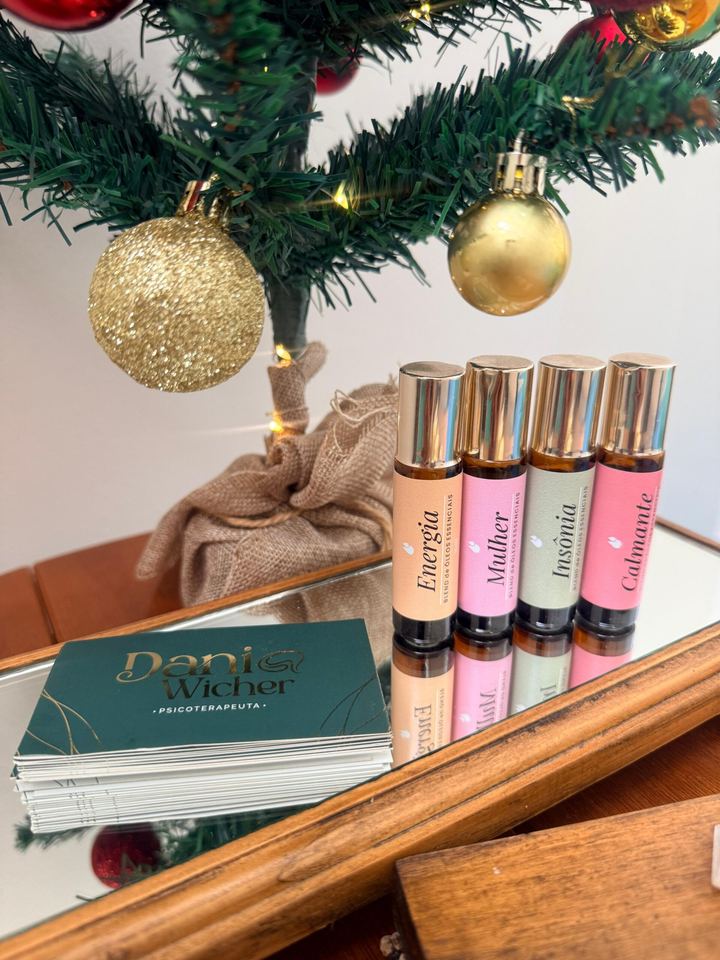 Árvore de Natal e frascos roll-on aromáticos sobre a mesa