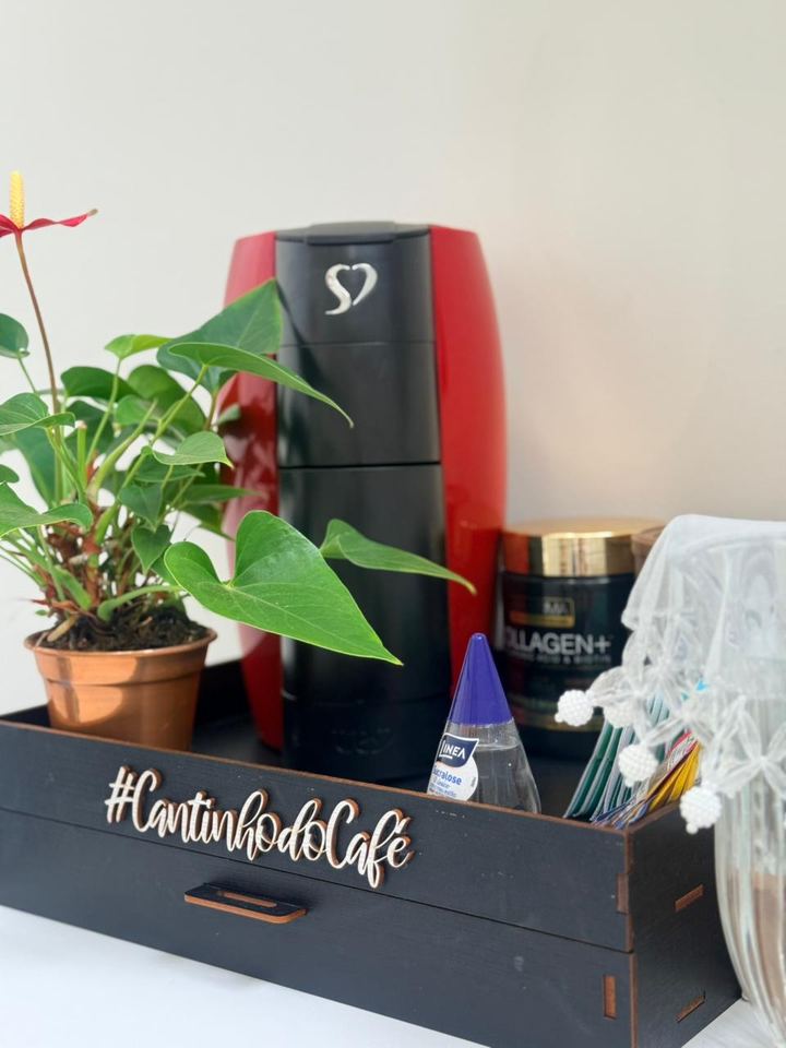 Cantinho do café com cafeteira vermelha, planta e bandeja