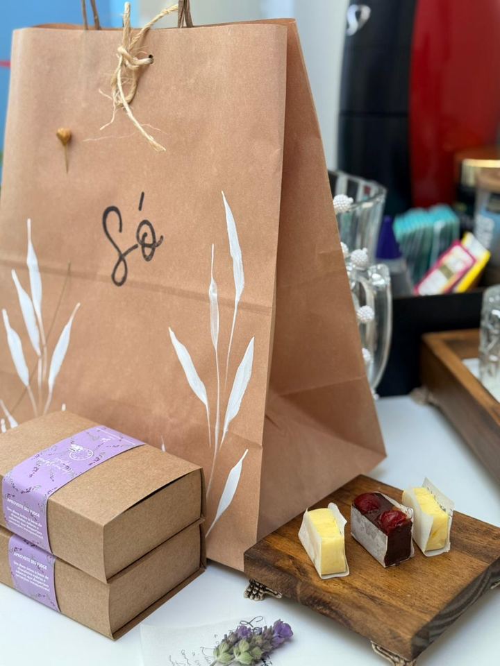 Sacola de papel kraft e caixas de doces sobre a mesa